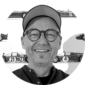 Rundes Portrait von Sam, Gründer der nuun gmbh, vor Rennwagen-Hintergrund – Agentur für Webdesign und Webentwicklung